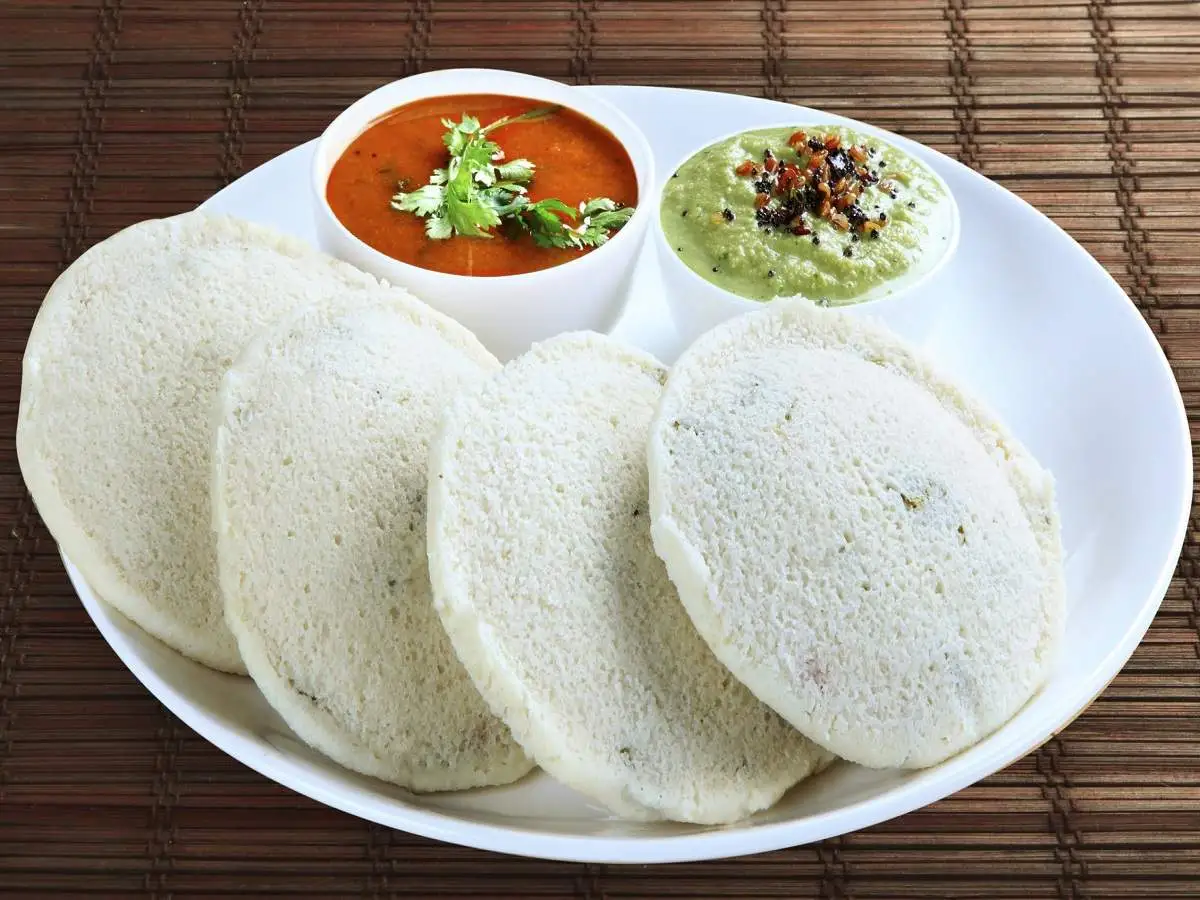 Steps Of Making Idli At Home, Showing Soaked Grains, Ground Batter, And Steamed Idlis In Molds.