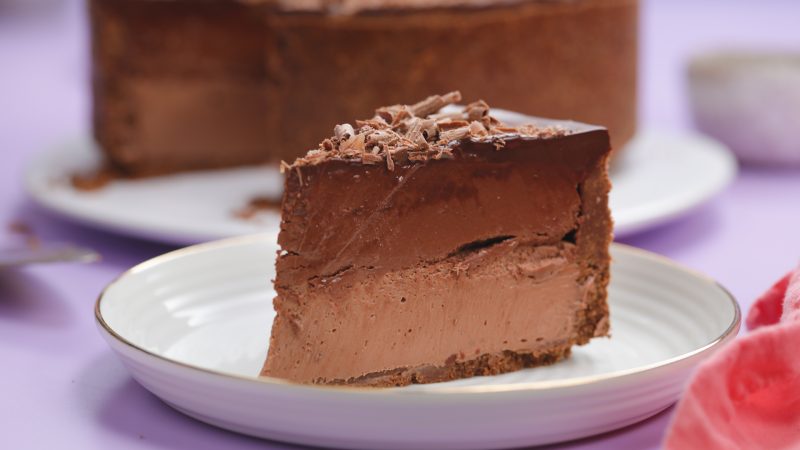 Potongan cheesecake coklat yang menggugah selera dengan saus coklat leleh, siap dinikmati