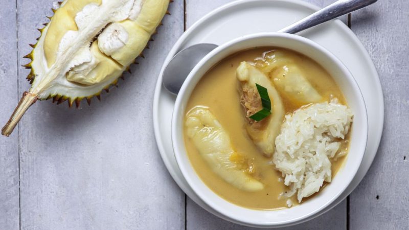 Semangkuk kolak durian dengan kuah santan gurih, potongan durian matang, dan gula aren cair yang manis